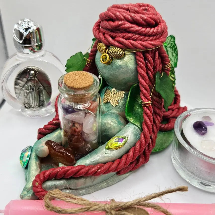 Close-up of Aisling Goddess Brigid figurine with carnelian, crystal vial and handmade decorative details