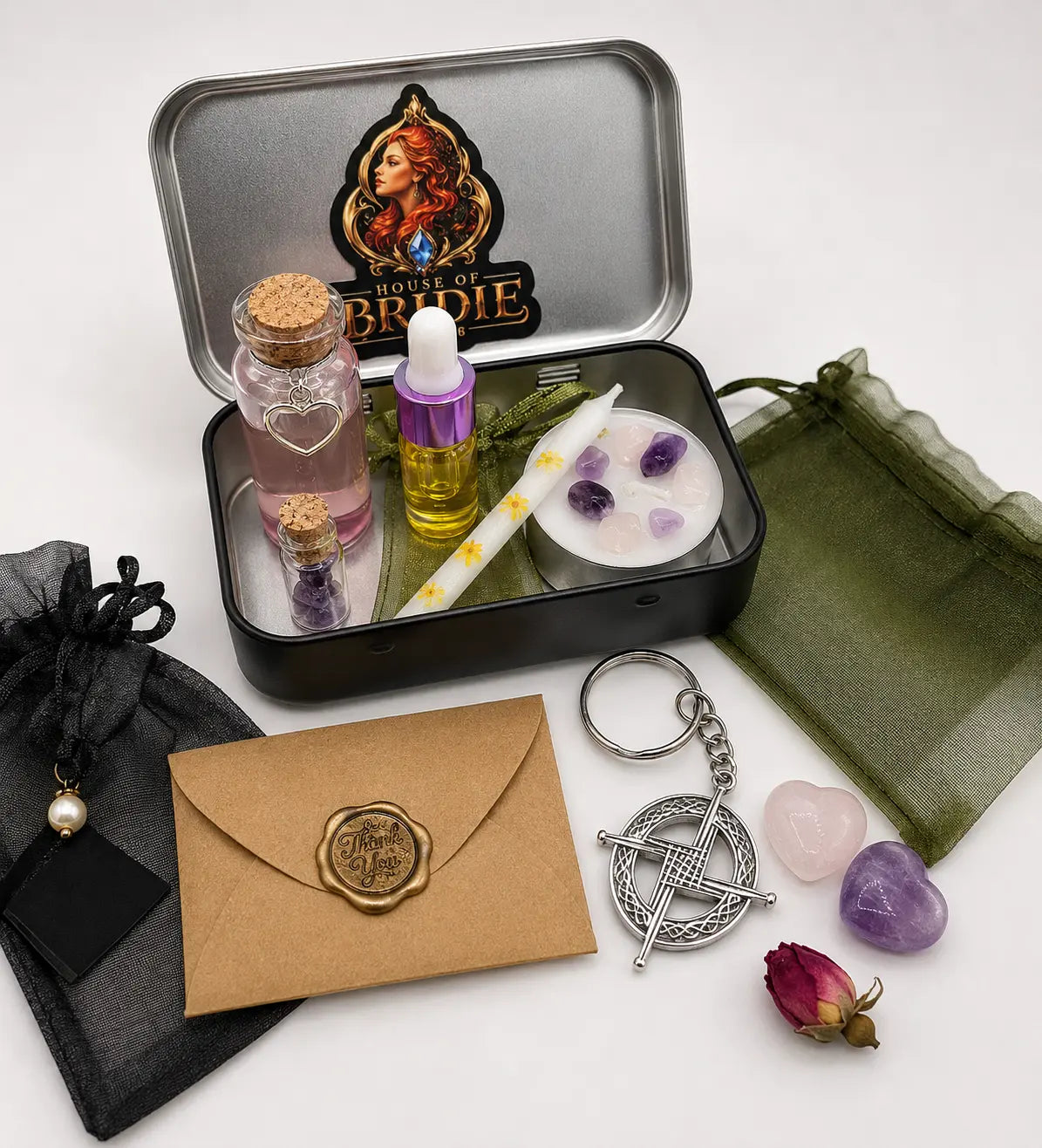 Brigid's Pocket Altar Kit with sacred waters, candles, altar oil, crystals and handcrafted ritual pieces, shown out of the tin