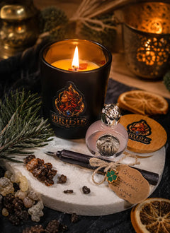 Brigid's Hearth Ritual Candle with Sweet Orange, Cedarwood and Myrrh beside a Brigid altar